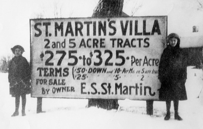 Sign with two girls flanking it.